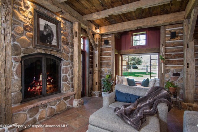 living room featuring beamed ceiling, wooden ceiling, and a fireplace