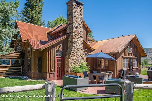 1150 Capitol Creek Rd, Snowmass, CO 81654 - rear view of property with a chimney, board and batten siding, a metal roof, and a patio