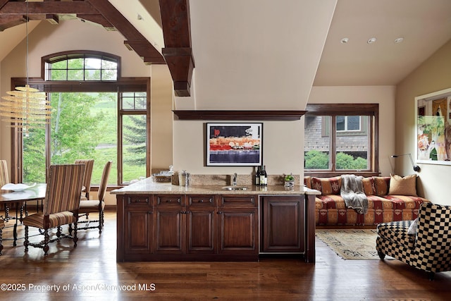 611 Oregon Trl, Aspen, CO 81611 - kitchen with vaulted ceiling, dark wood-style flooring, dark brown cabinetry, light stone counters, and open floor plan