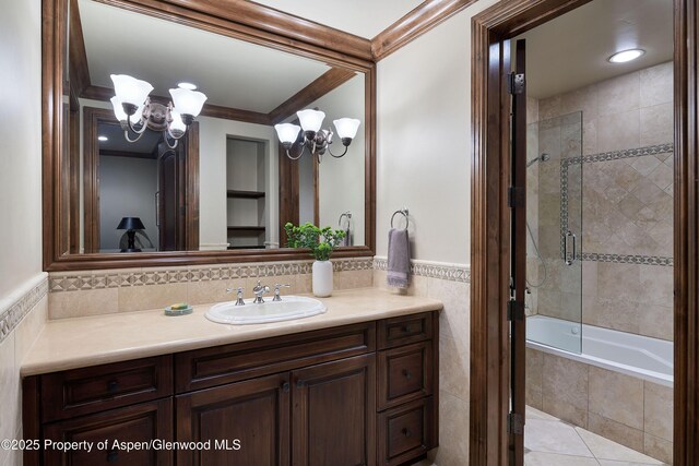 611 Oregon Trl, Aspen, CO 81611 - full bath featuring a chandelier, vanity, crown molding, tiled shower / bath, and tile walls