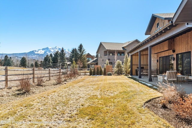 view of yard with fence, a patio, and a mountain view