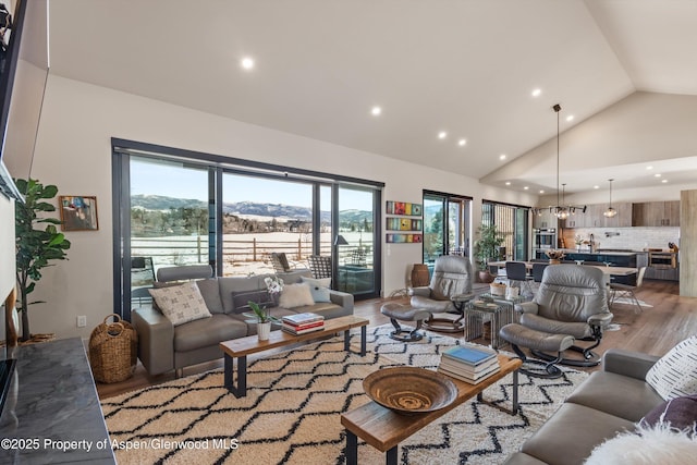 living area featuring light wood-style floors, high vaulted ceiling, and recessed lighting