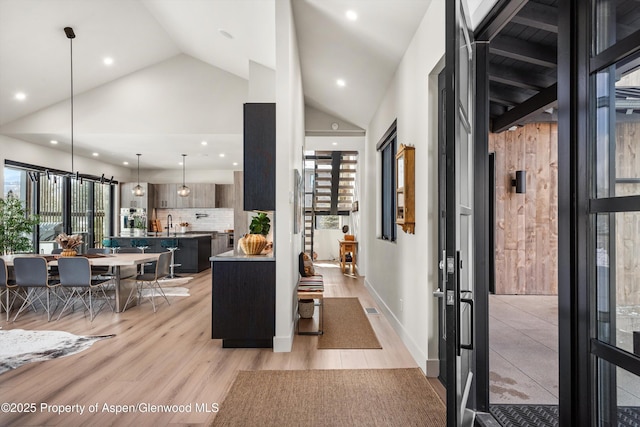 foyer entrance with high vaulted ceiling, light wood-type flooring, plenty of natural light, and recessed lighting