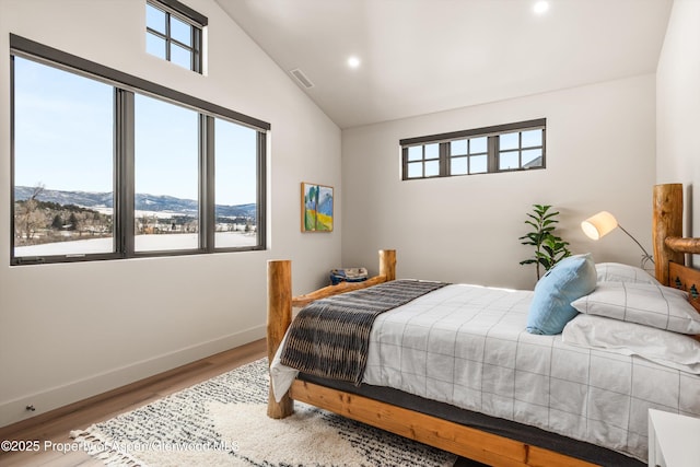 bedroom with wood finished floors, visible vents, and multiple windows