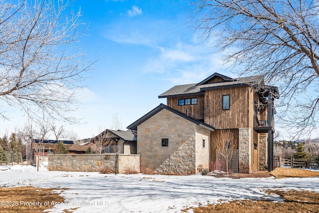 exterior space with stone siding and fence