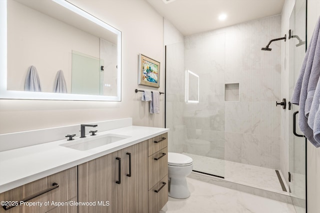 full bathroom featuring marble finish floor, vanity, a tile shower, and toilet