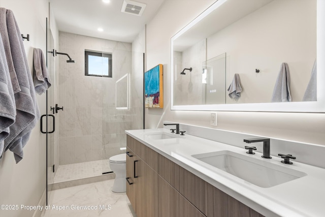 bathroom featuring marble finish floor, visible vents, a sink, and a shower stall