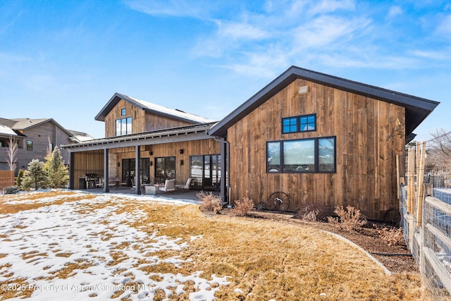 snow covered house featuring a patio