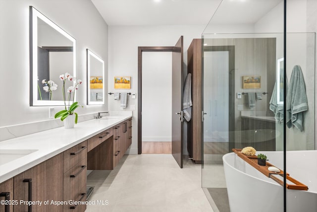 bathroom with double vanity, a soaking tub, a shower with door, tile patterned floors, and a sink