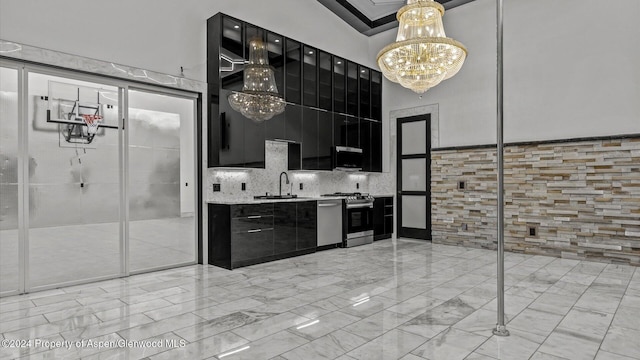 kitchen featuring backsplash, a notable chandelier, sink, and stainless steel stove