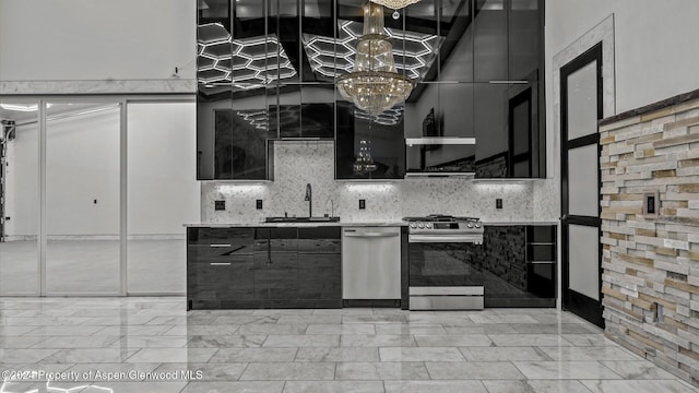 kitchen featuring backsplash, sink, appliances with stainless steel finishes, and a chandelier