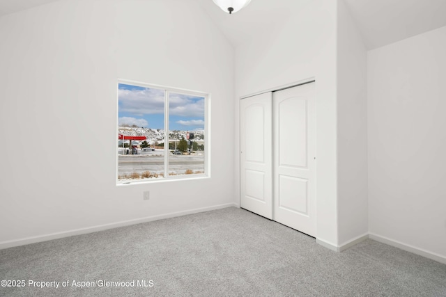 unfurnished bedroom featuring a towering ceiling, carpet flooring, and a closet