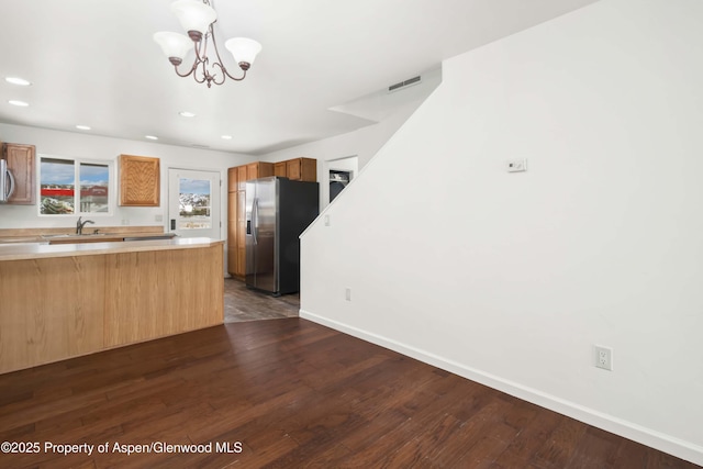 kitchen featuring sink, decorative light fixtures, dark wood-type flooring, and appliances with stainless steel finishes