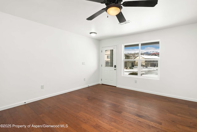 spare room featuring dark wood-type flooring and ceiling fan