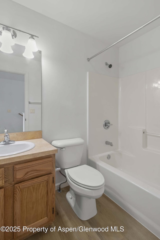 full bathroom featuring wood-type flooring, shower / bathing tub combination, vanity, and toilet