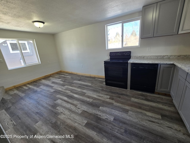 kitchen with gray cabinetry, dark hardwood / wood-style floors, a textured ceiling, and black appliances