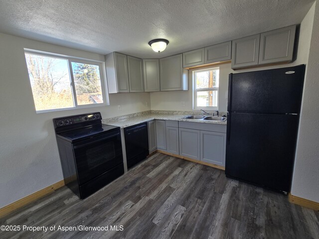 kitchen featuring sink, gray cabinetry, dark hardwood / wood-style floors, and black appliances