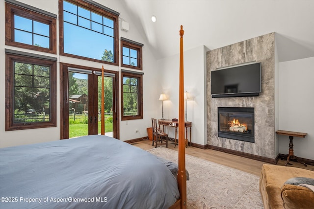 11 Pinon Ln, Carbondale, CO 81623 - bedroom featuring wood finished floors, a fireplace, access to exterior, and high vaulted ceiling