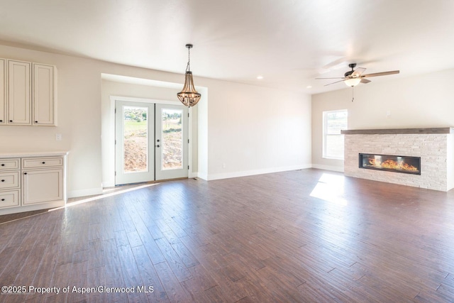 682 Eagles Nest Dr, Silt, CO 81652 - unfurnished living room featuring healthy amount of natural light, dark wood-style floors, ceiling fan, a stone fireplace, and recessed lighting