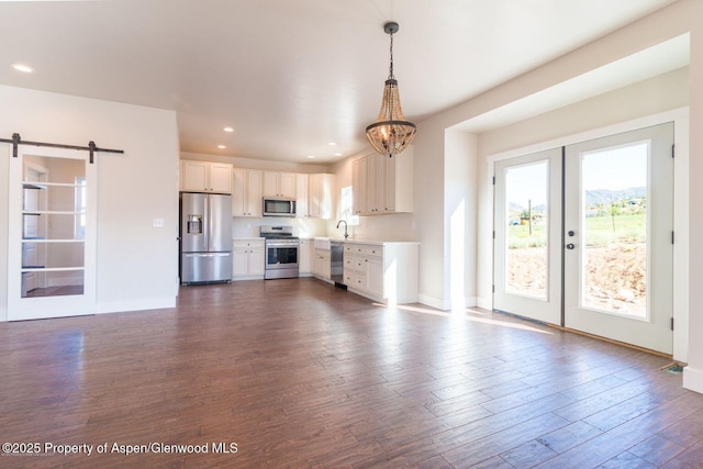 682 Eagles Nest Dr, Silt, CO 81652 - kitchen with stainless steel appliances, french doors, a barn door, light countertops, and a chandelier
