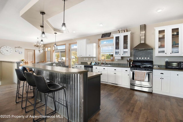 22 Booms Pl, Rifle, CO 81650 - kitchen featuring appliances with stainless steel finishes, dark countertops, wall chimney exhaust hood, dark wood finished floors, and recessed lighting