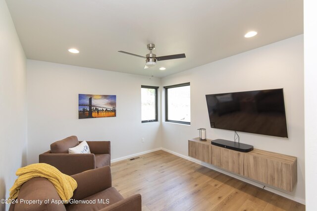 living room with ceiling fan and light wood-type flooring