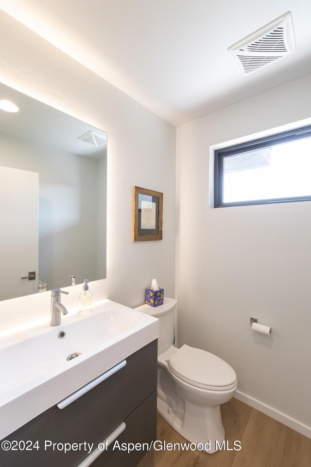 bathroom with vanity, hardwood / wood-style flooring, and toilet