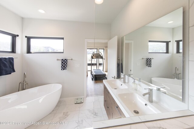 bathroom with vanity and a tub to relax in