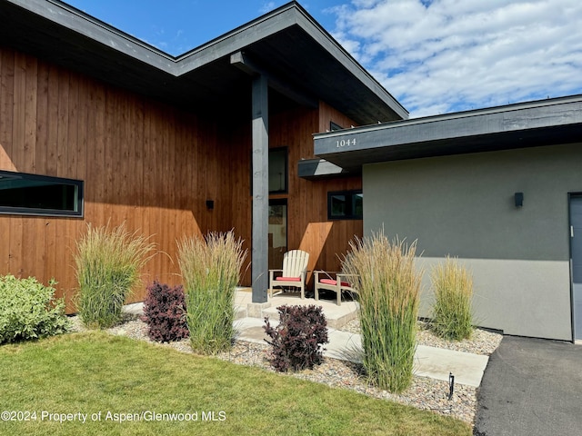 property entrance featuring a lawn