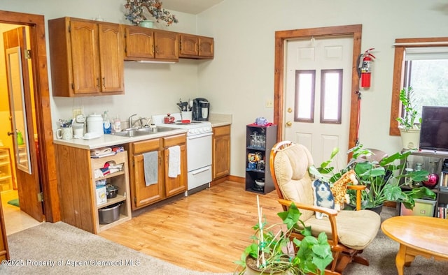 337 E 5 Th St, Rifle, CO 81650 - kitchen with white electric range, light countertops, brown cabinets, and light wood finished floors