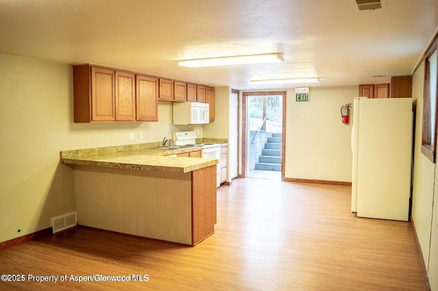 337 E 5 Th St, Rifle, CO 81650 - kitchen featuring white appliances, light wood finished floors, a peninsula, and light countertops