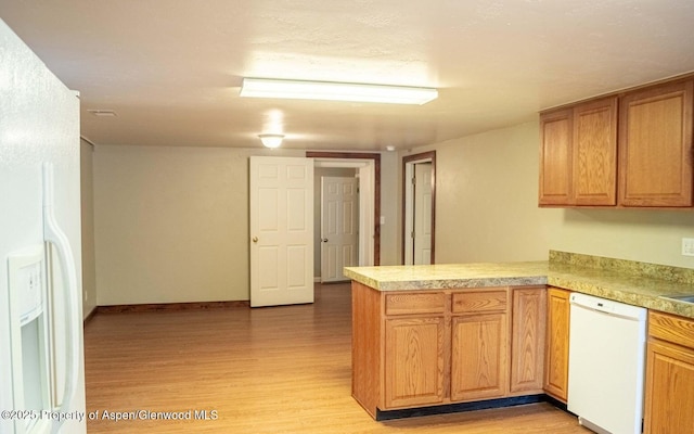 337 E 5 Th St, Rifle, CO 81650 - kitchen with white appliances, a peninsula, light wood-style floors, light countertops, and brown cabinets