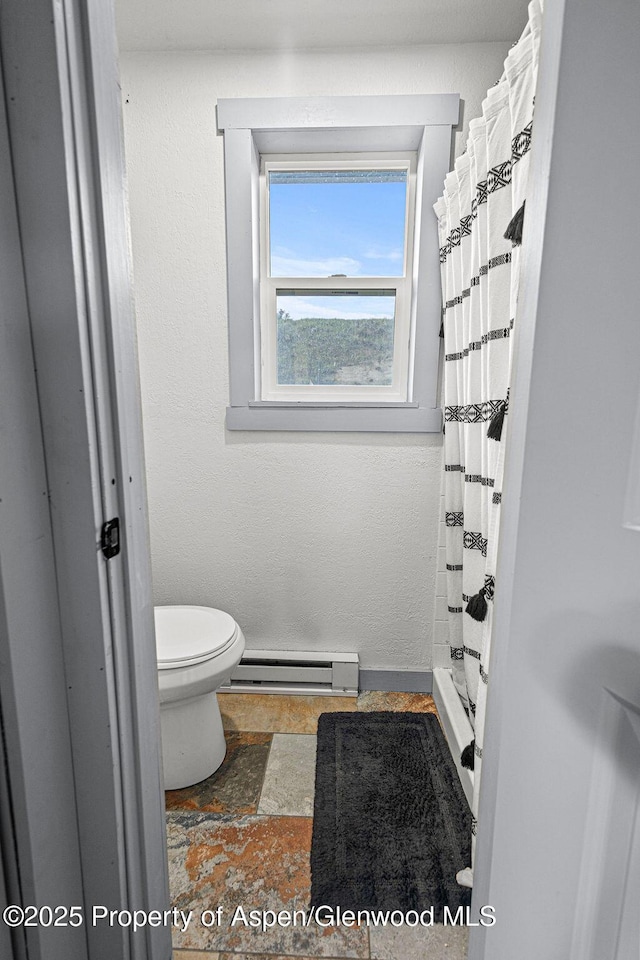 3598 County Road 35, Craig, CO 81625 - bathroom featuring a baseboard heating unit, toilet, and a shower with curtain