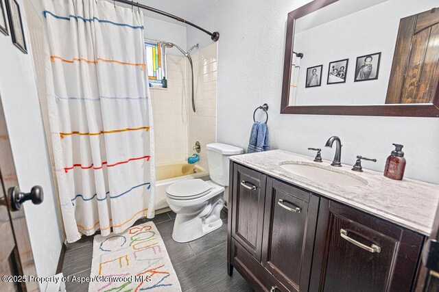 3598 County Road 35, Craig, CO 81625 - full bathroom with toilet, vanity, shower / tub combo with curtain, and a textured wall