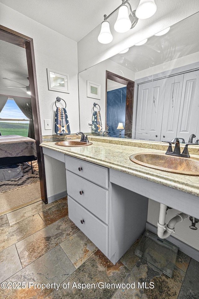 3598 County Road 35, Craig, CO 81625 - ensuite bathroom with stone tile flooring, double vanity, and a textured ceiling