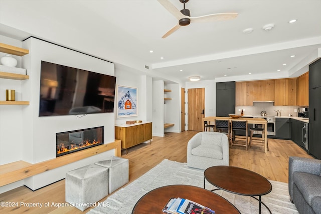 living room with light hardwood / wood-style flooring and ceiling fan