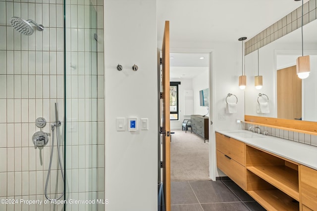 bathroom featuring a tile shower, tile patterned floors, and vanity