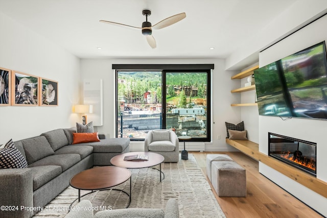 living room with ceiling fan and hardwood / wood-style flooring