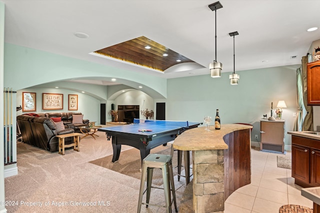 recreation room featuring a raised ceiling and light tile patterned floors