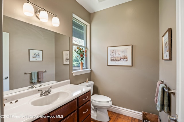 bathroom with vanity, toilet, and wood-type flooring