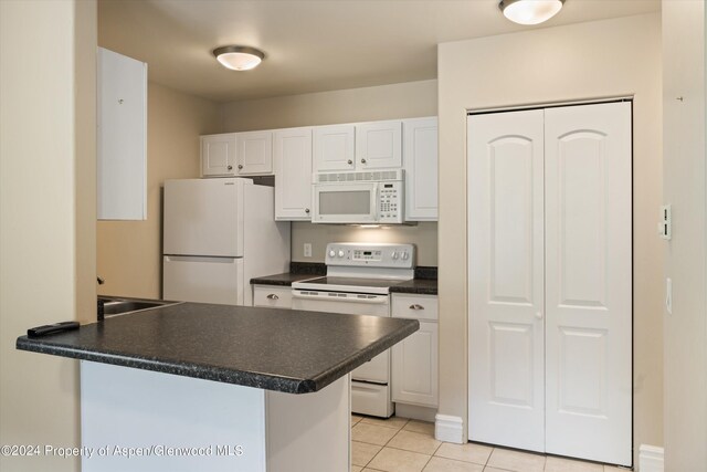 kitchen featuring kitchen peninsula, white appliances, white cabinetry, and light tile patterned flooring