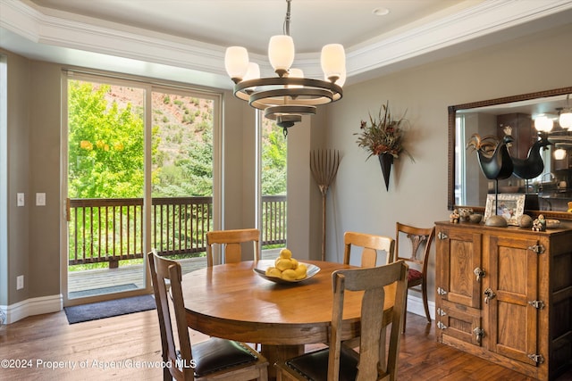 dining room featuring hardwood / wood-style flooring, crown molding, and an inviting chandelier