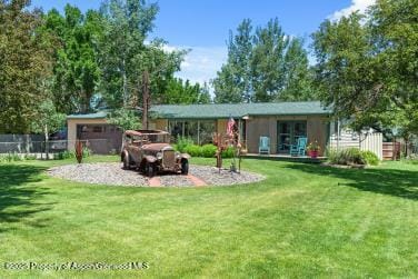 back of house featuring a yard and fence