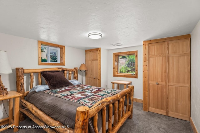 carpeted bedroom with visible vents, baseboards, and a textured ceiling