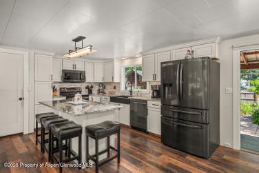 kitchen with dishwasher, plenty of natural light, range, and black fridge