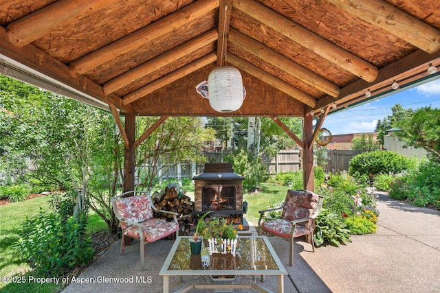 view of patio / terrace featuring an outdoor living space with a fireplace and fence