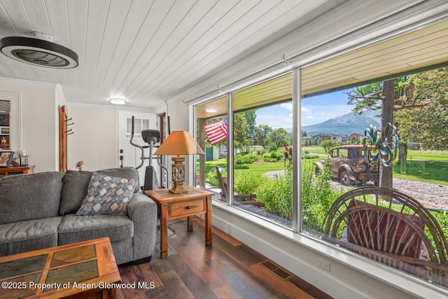 living area featuring visible vents, a mountain view, crown molding, wood ceiling, and dark wood-style flooring