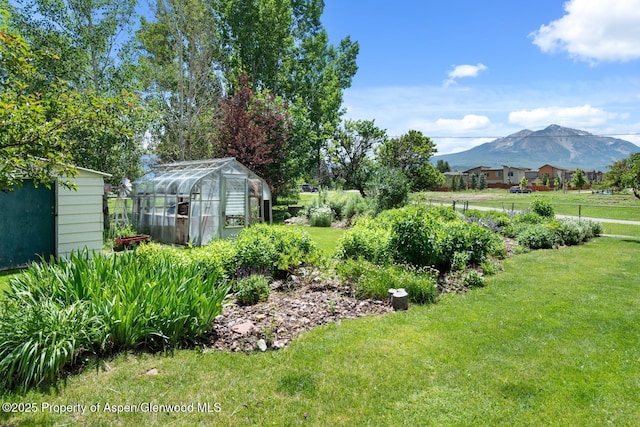 view of yard featuring an outdoor structure, a mountain view, and an exterior structure