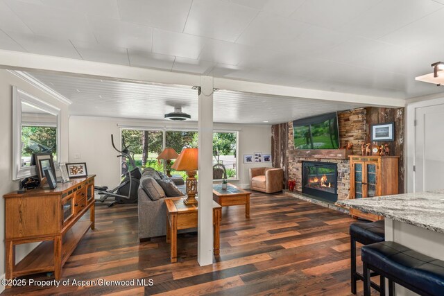 living room with dark wood-type flooring and a fireplace