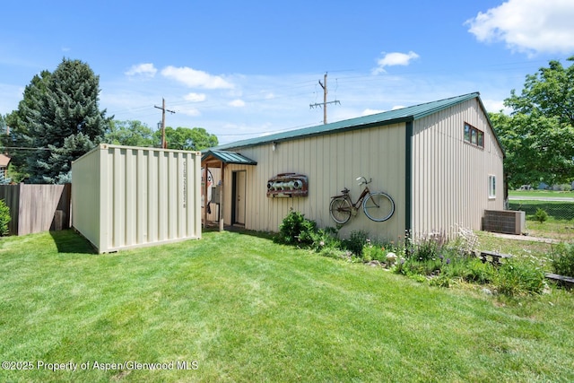 view of outdoor structure with central air condition unit, an outdoor structure, and fence